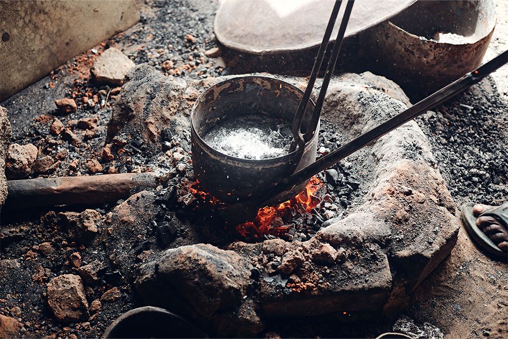 A crucible with molten material in it to suggest tragic hero examples 