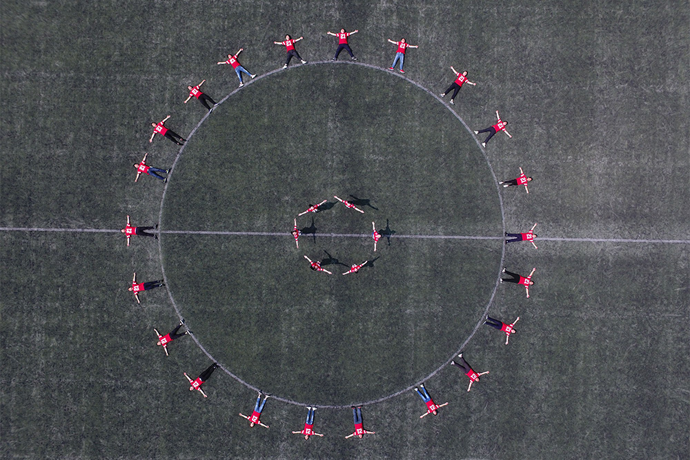 A large ring of people lying down with an inner ring embracing suggests the types of characters on the inner circle