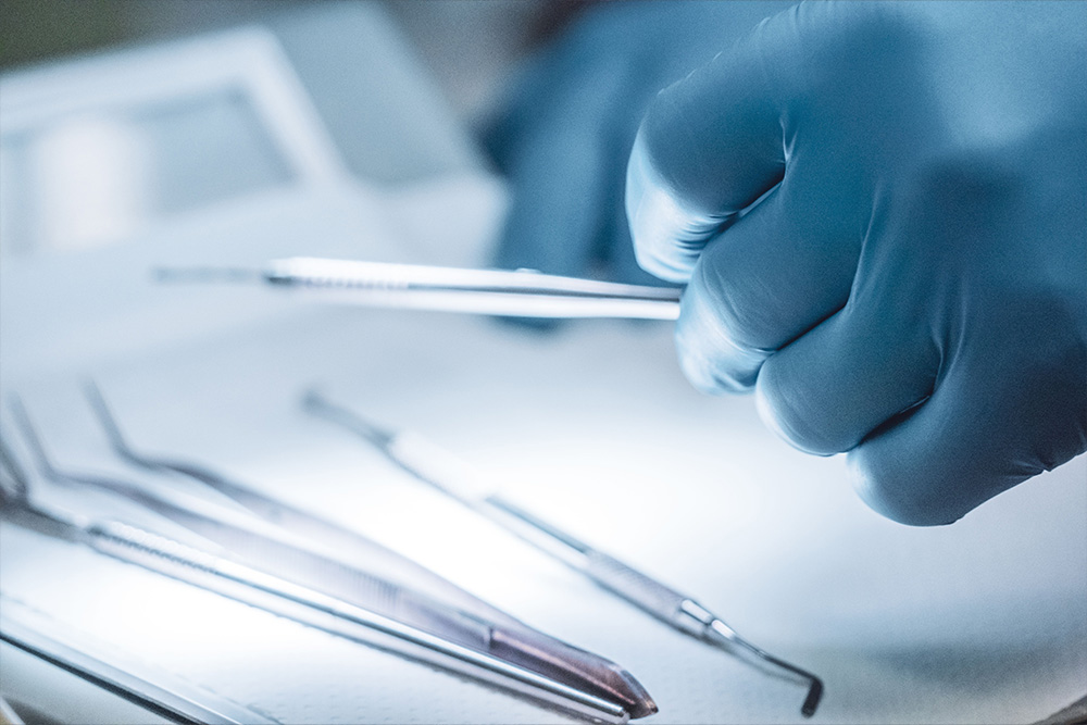 A surgical gloved hand picking up a scalpel from a group of instruments to suggest cutting open a story with these types of characters