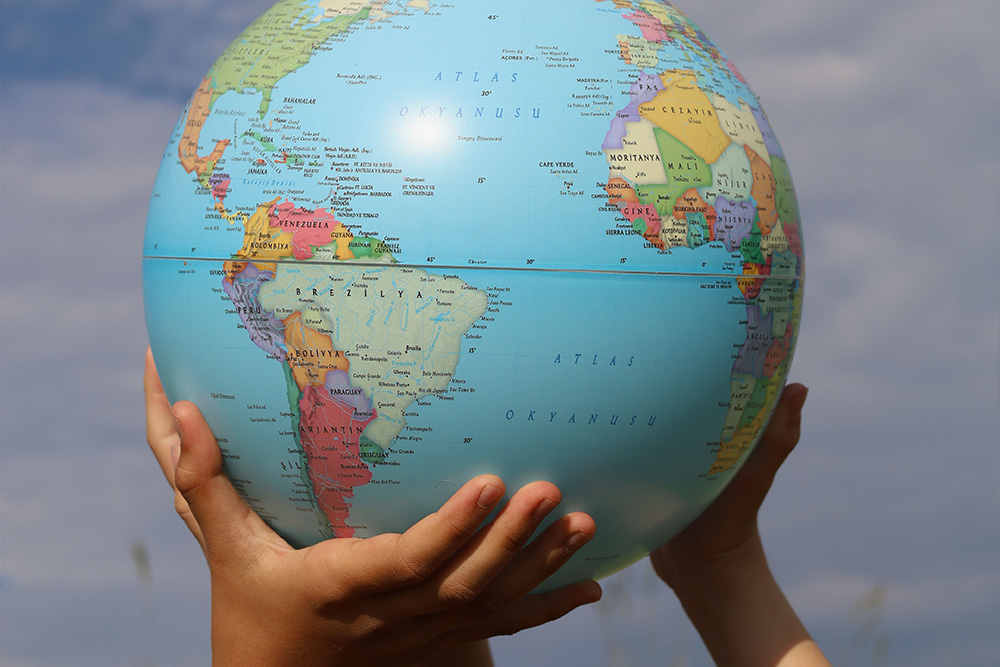 Children hold up a globe to suggest how these types of characters show up in a story to reflect the world to a protagonist