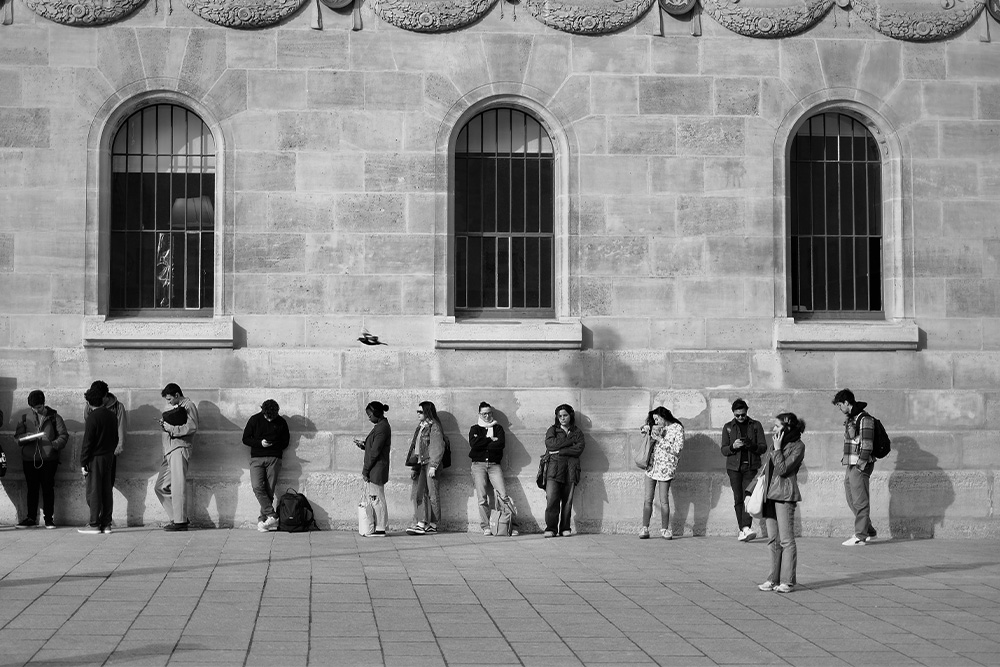 People waiting in line at a building in stark black and white to suggest waiting to figure out the writing rules is unproductive 