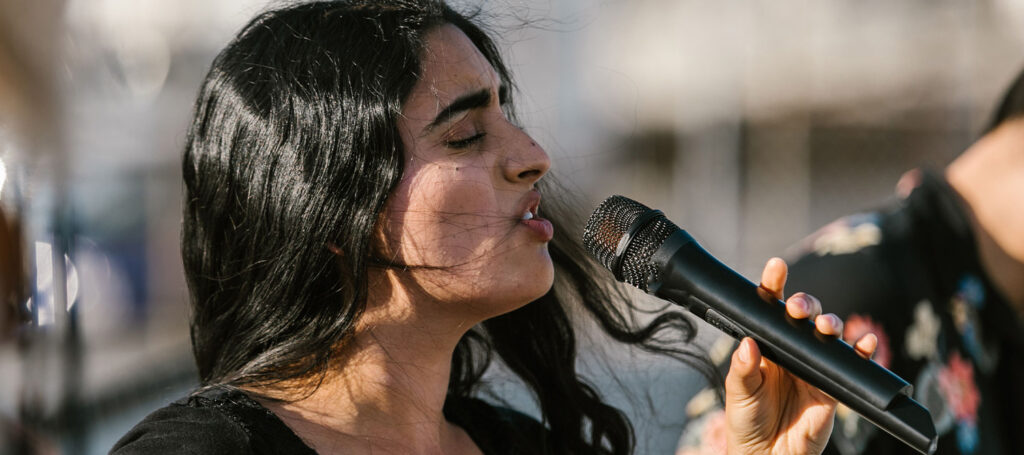A woman singing into a microphones as a visualization for style and voice in elements of fiction