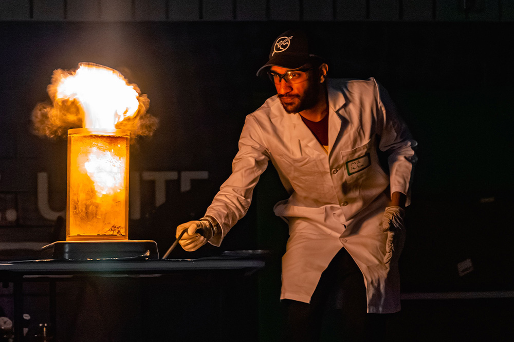 A chemist setting a fire a light to give the magician archetype a sense of power