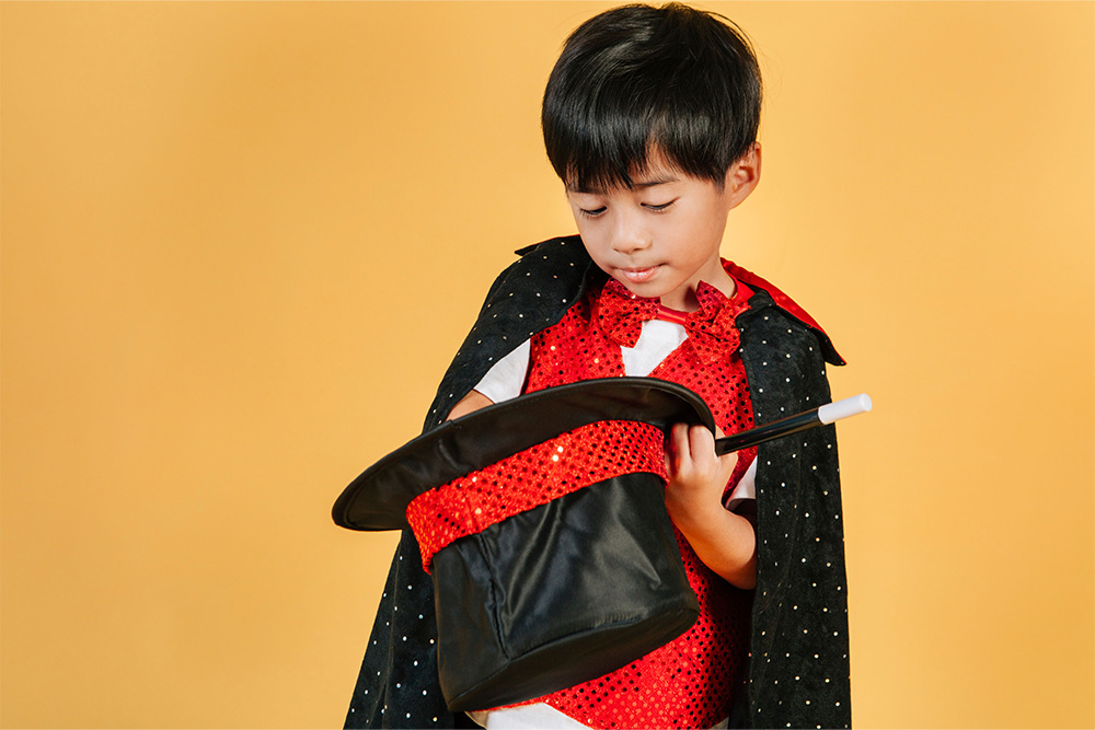 A child reaching into a hat to suggest play in the magician archetype