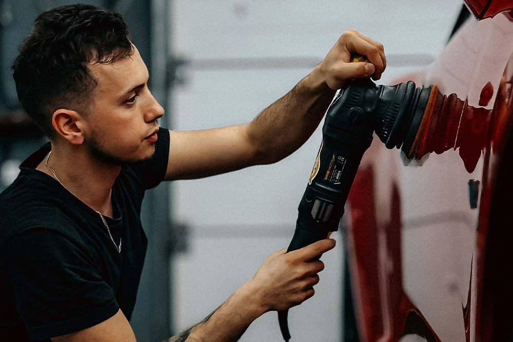 A man buffing out the paint on a car to suggest that a finished, polished manuscript is like this process of car finishing for book proposals