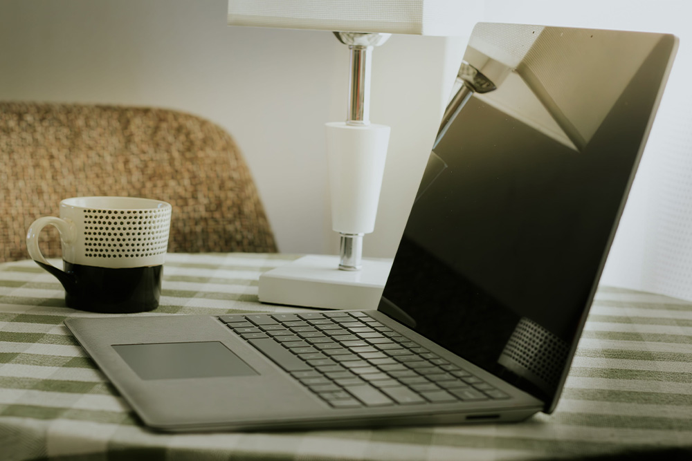 A laptop open with an empty cup next to it as a suggestion of how the dramatic question exists