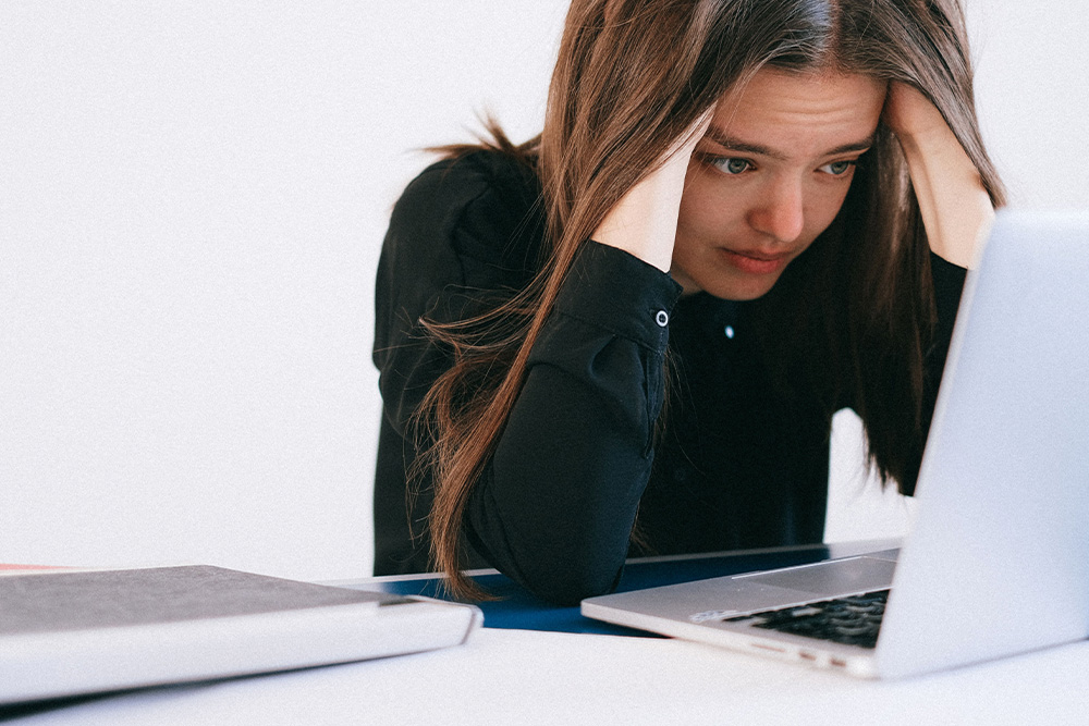 A woman struggling at her laptop suggesting trouble finding the dramatic question