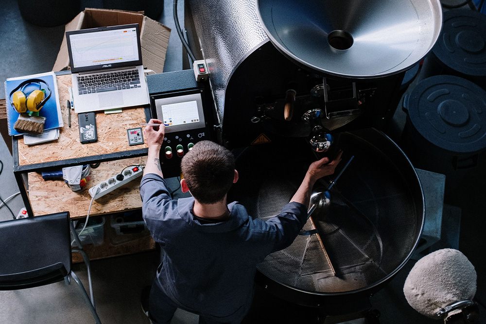 A person compressing a coffee machine and writing diligent notes — visual parallel for how to get a book deal