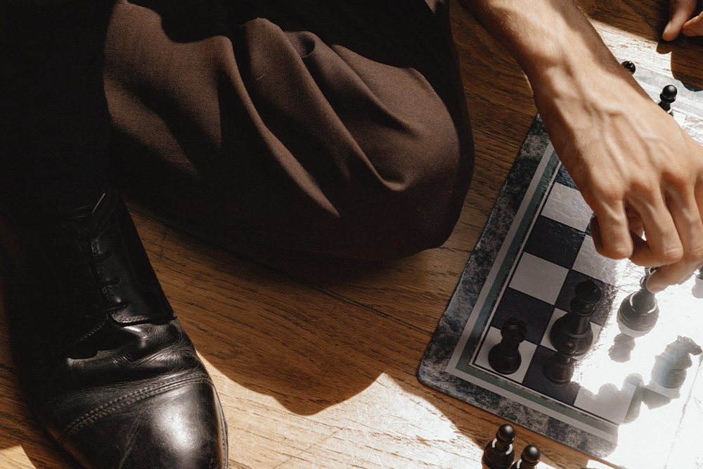 Somone in a business outfit playing a game of chess to suggest a more tactical approach to publishing with hybrid publishing