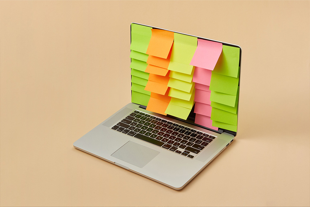A laptop covered with a bunch of sticky notes