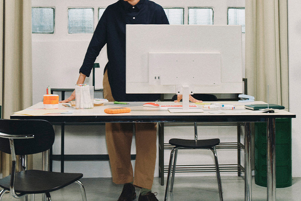A person at a traditional working desk with splashes of color to suggest a new and old mix for hybrid publishing