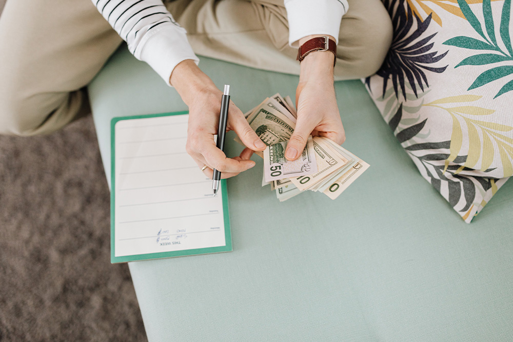 Someone counting money to suggest how being a kindlepreneur will allow a smooth transition into business from writing