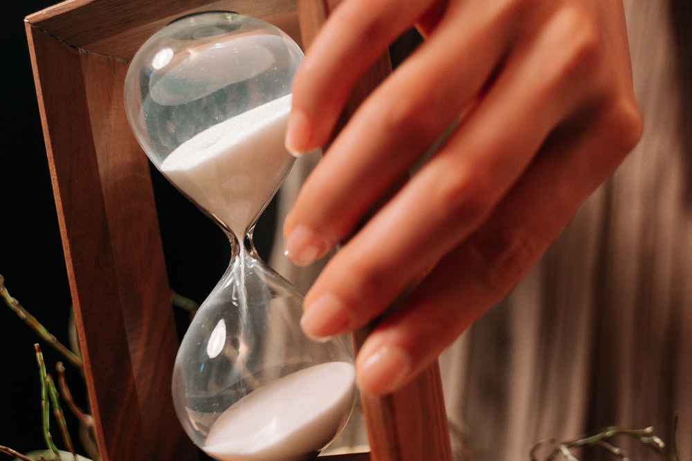 An hourglass with sand in it being flipped over to suggest that discipline is required to move through time as a kindlepreneur