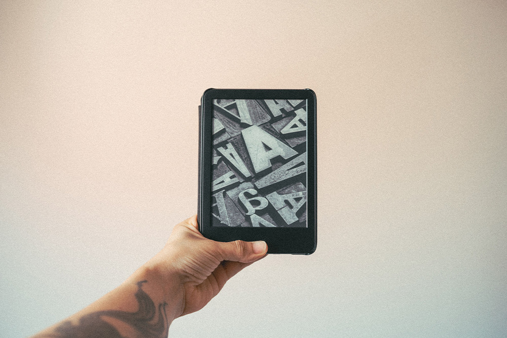 A kindle being held up in a frame for the kindlepreneur to be invited into this blog