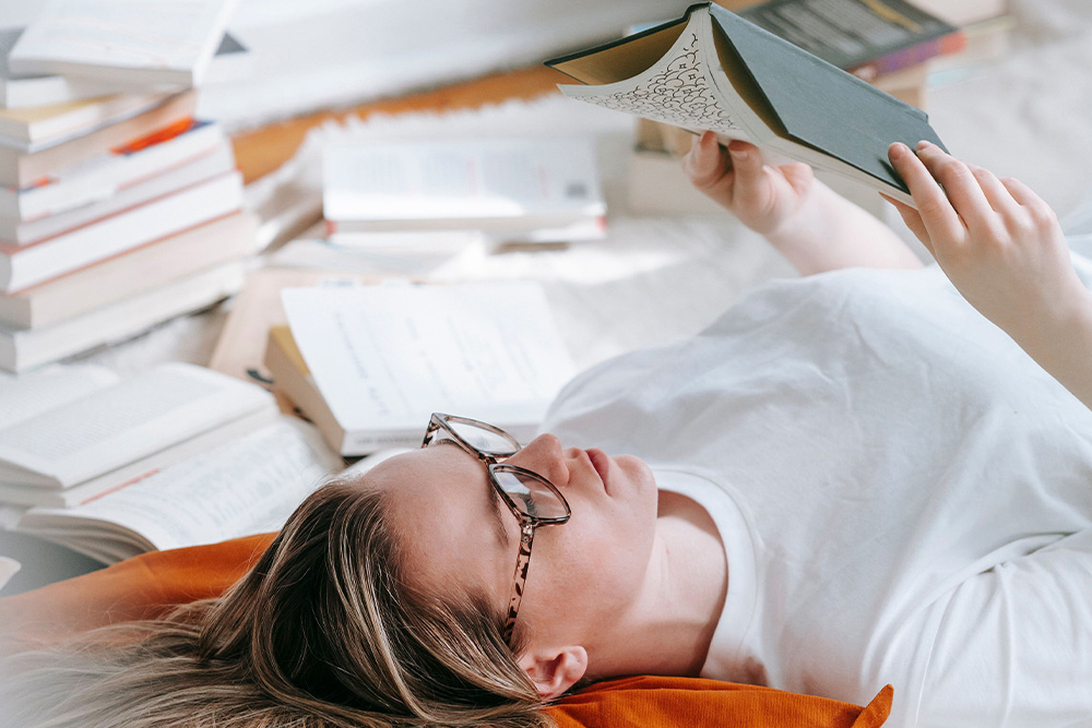 A reader surrounded by many novels to suggest that you can trust your readers in literary fiction