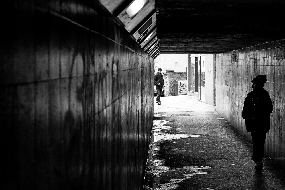 A man gazing at a woman in a dark tunnel to suggest reading a mixed metaphor like a stranger
