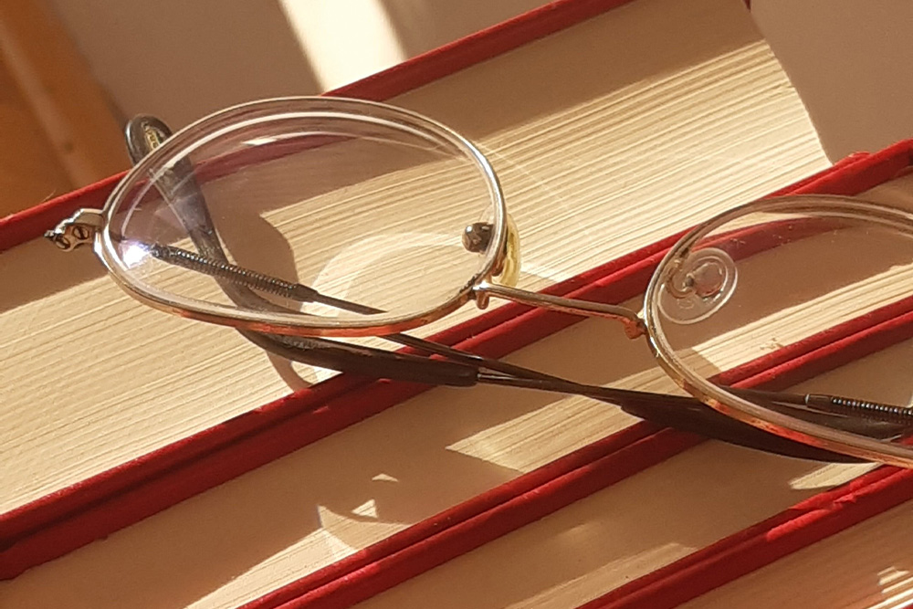 A pair of glasses on a series of books to suggest noticing syntax