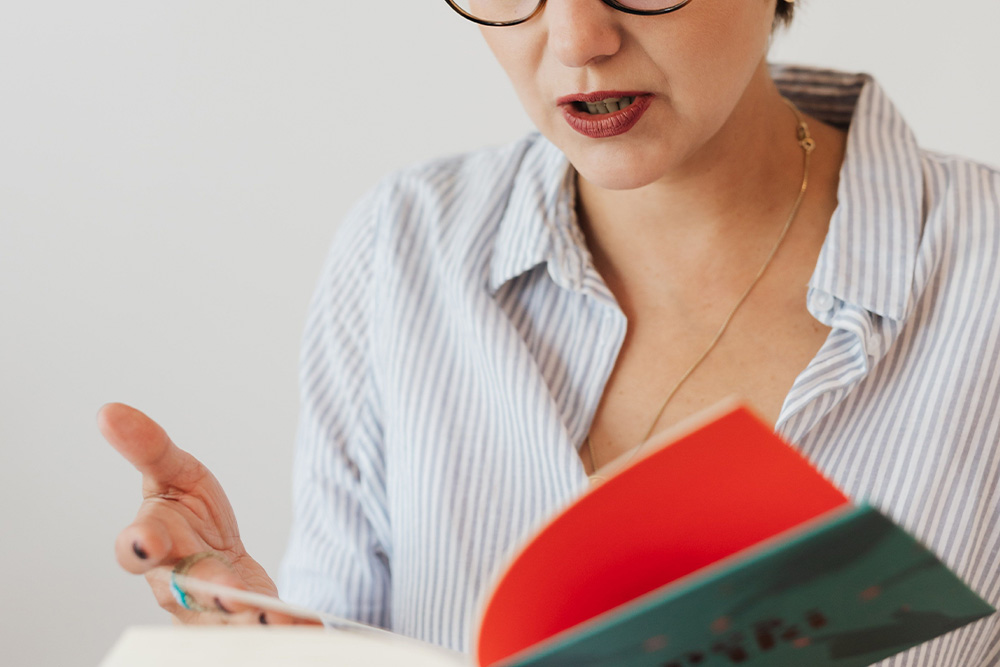 A woman reading aloud to suggest finding syntax by sounding sentences out