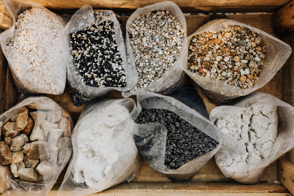 Different size rocks are ground and grouped differently to suggest that different material ends up in different places based on theme ideas