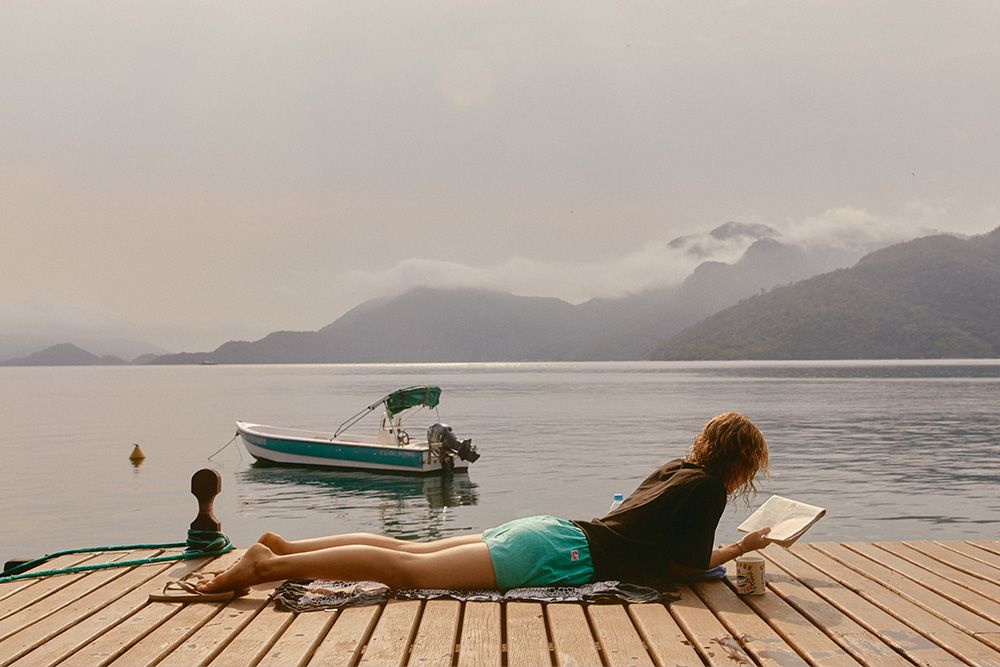 A woman reading in a serene environment to suggest how vivid verbs bring a text alive