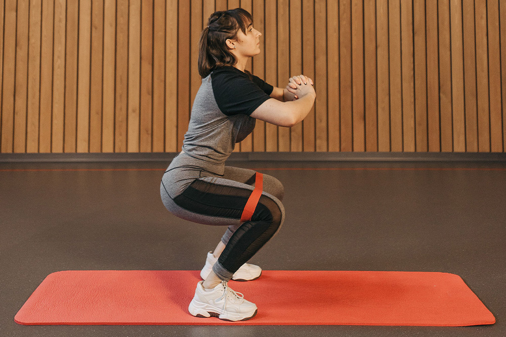 A woman doing resistance training as a visual for how to explain writing motivation as a progressive goal