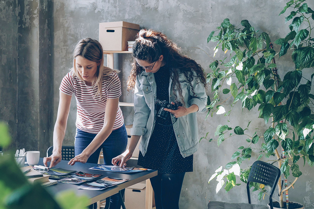 A studio and two women working within it surrounded by life and plants