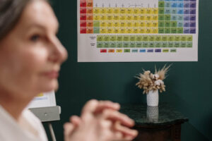 A periodic table of elements next to a woman's face to suggest thinking about the elements of fiction