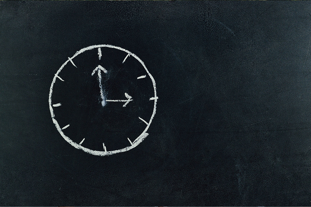 A clock depicted in chalk on a blackboard to evoke childhood/schoolteaching in relation to a teenager's sense of time in young adult fiction