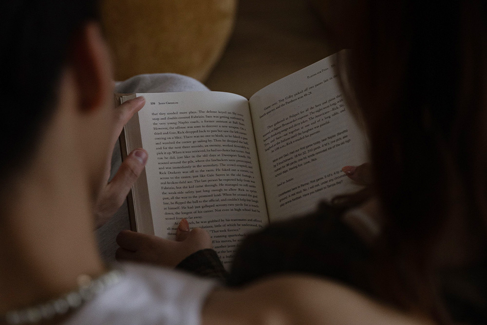 Characters reading a book together to suggest how characters suggest plot 