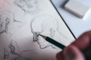 A creative writer taking time to sketch out their protagonist, who they know more about thanks to the character questionnaire.