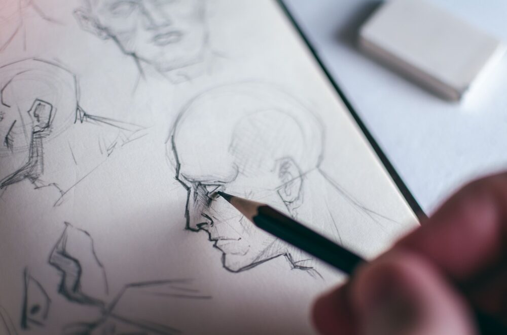 A creative writer taking time to sketch out their protagonist, who they know more about thanks to the character questionnaire.