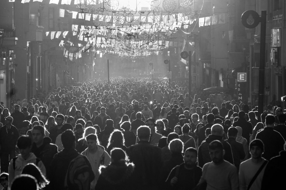 A crowd of people in grayscale, symbolizing the fourth person point of view.